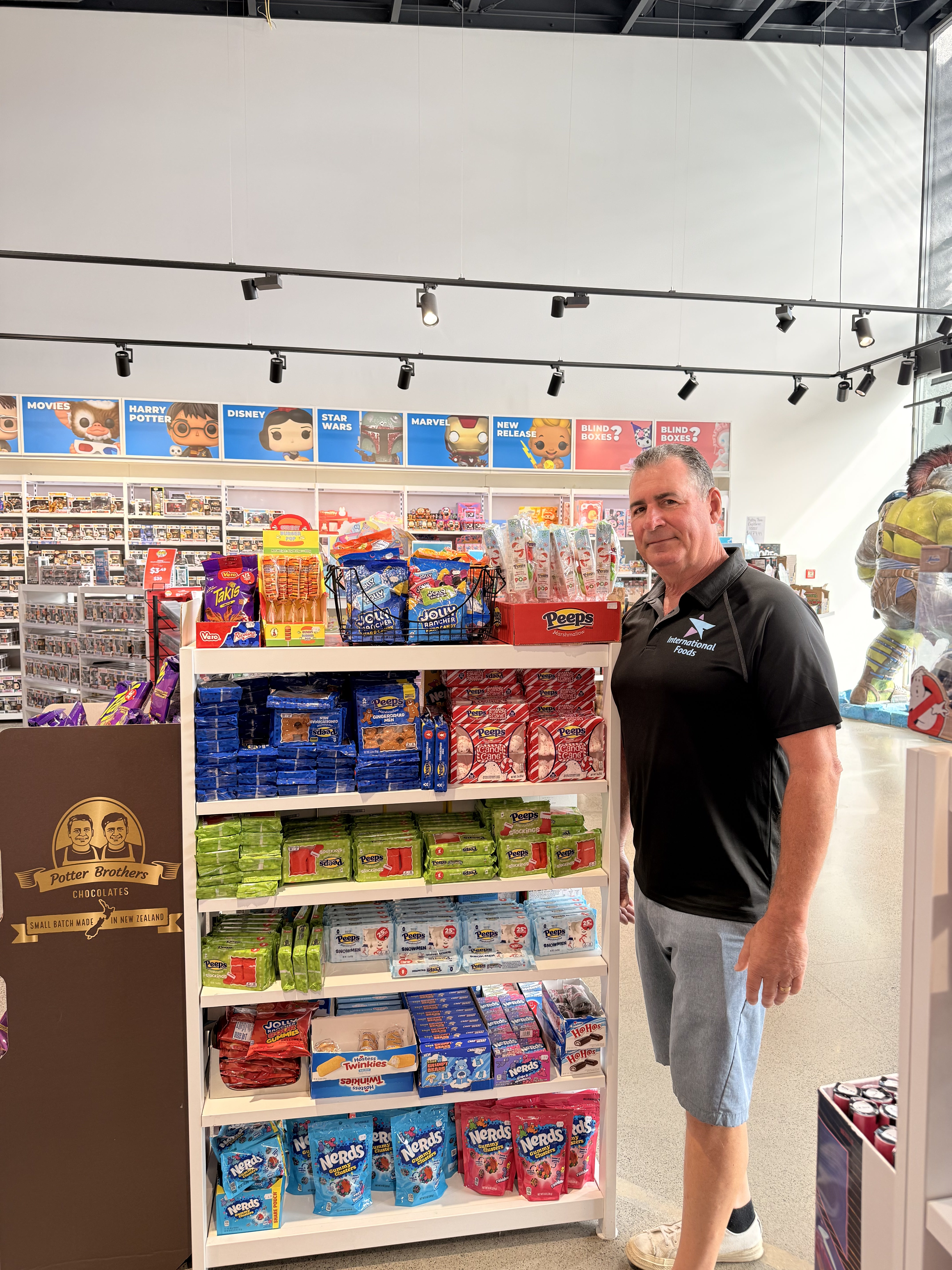 Steve Sartin beside an international confectionery display